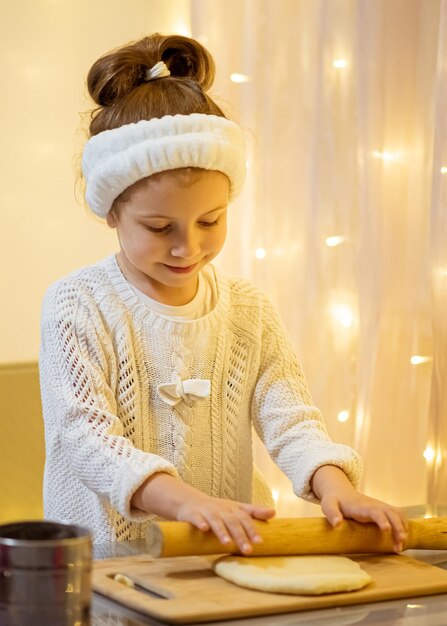 Ein kleines süßes Mädchen macht Weihnachtsplätzchen. Haus. Neujahr. Kompfort.