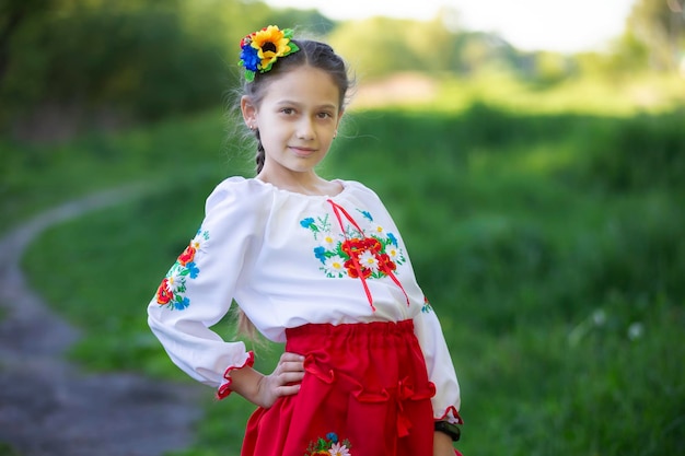 Ein kleines ukrainisches und belarussisches Mädchen in einem bestickten Hemd auf sommerlichem Hintergrund