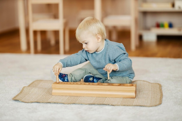 Ein Kleinkind spielt im Kindergarten mit Holzspielzeug und lernt Formen