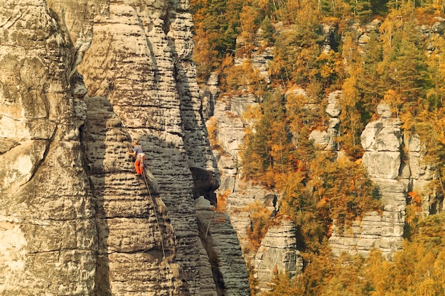 Ein Kletterer auf der Oberfläche des Berges in einem Wald