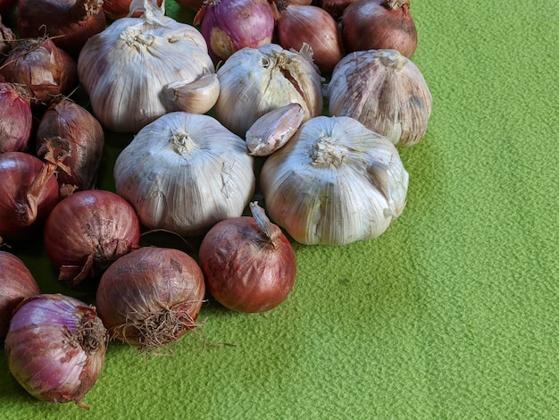 Ein Knoblauch und rote Zwiebeln auf grünem Hintergrund