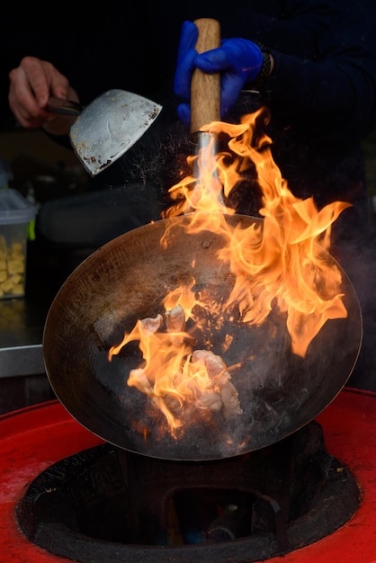 Ein Koch bereitet chinesisches Essen auf einem Streetfood-Festival zu