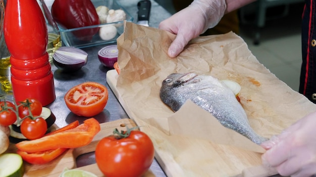 Ein Koch, der in der Küche arbeitet und den Fisch für das Backen vorbereitet