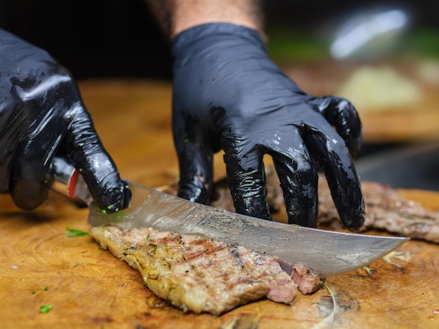 Ein Koch in der Küche schneidet ein Steak