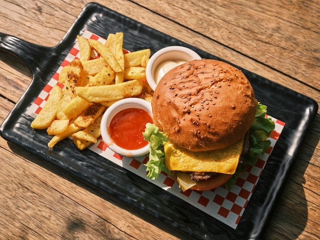 Ein köstlicher Cheeseburger mit Pommes Frites und Saucen