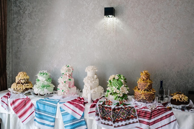 Ein köstliches süßes Hochzeitsbrot im ukrainischen Stil auf bestickten Handtüchern Festlicher süßer Tisch