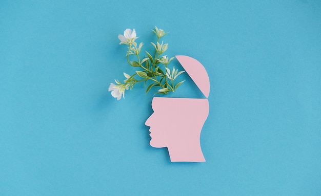 Ein Kopf mit einer Blume ist auf einem blauen Hintergrund