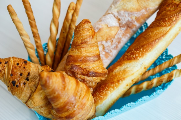 Ein Korb mit frischem Gebäck, Croissants und Brot. Vollkornbackwaren, hefefreies Brot