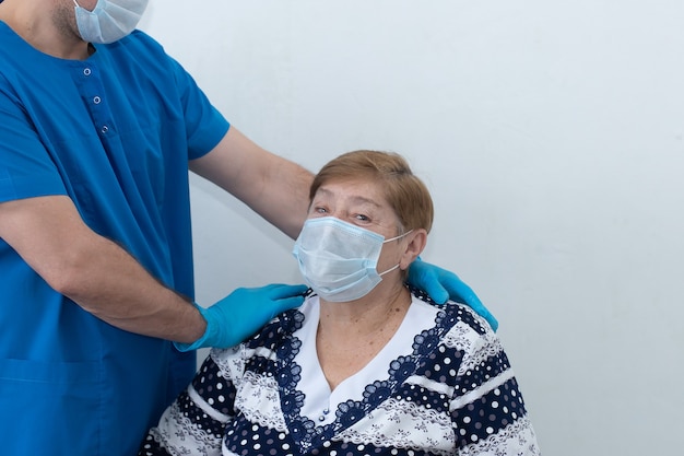 Ein Krankenpfleger mit einem älteren Patienten auf der Station