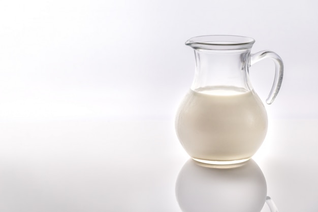 Ein Krug Milch auf der weißen Oberfläche