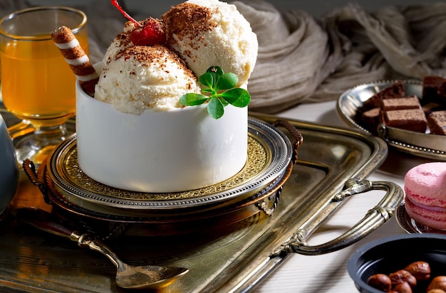 Ein Kuchen mit Vanilleeis oben drauf und einer Tasse Schokoladensirup als Beilage.