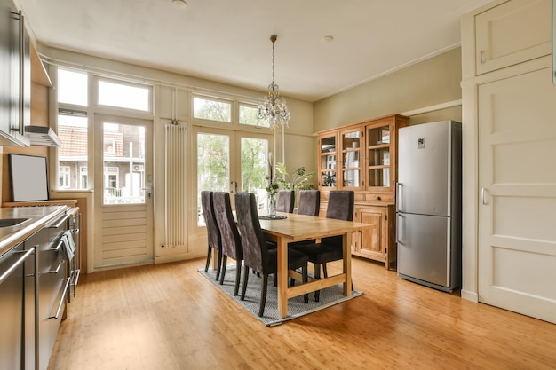 Foto ein küchen- und esszimmerbereich in einem haus mit holzflächen, weißen wänden und türen, die nach außen öffnen