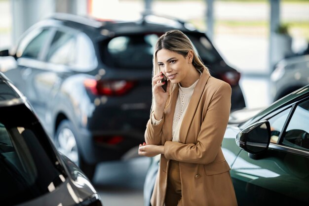 Ein Kundenbetreuer steht im Salon des Autohauses und spricht mit Kunden