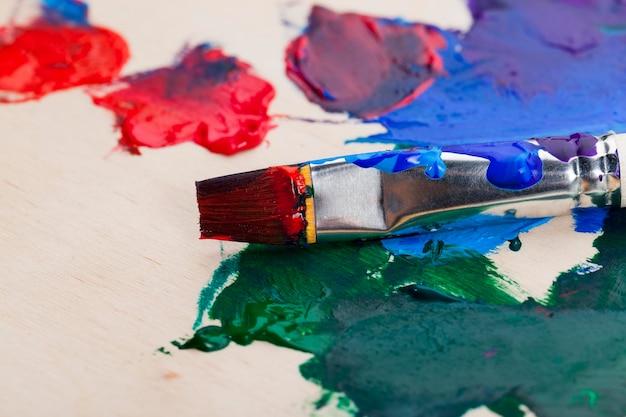 Ein Kunstpinsel und verschiedene Arten von Farbe, mehrfarbige Farben und ein Pinsel, nachdem Sie damit Bilder gezeichnet haben
