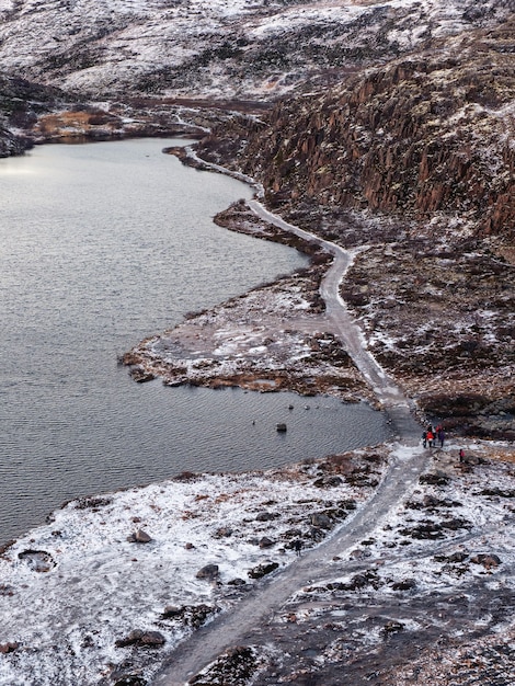 Ein kurvenreicher Bergweg zwischen den schneebedeckten arktischen Hügeln.