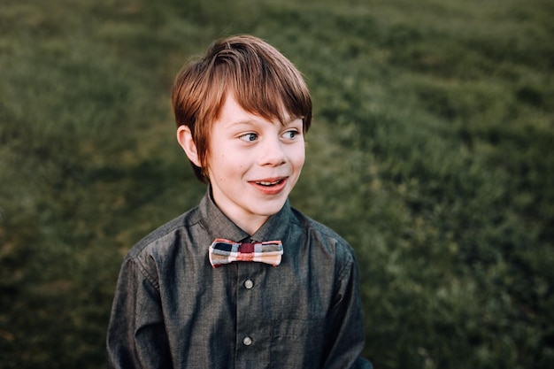 Foto ein lächelnder junge schaut weg, während er draußen steht