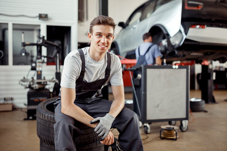 Ein lächelnder junger Mann ist während einer Pause an einem Autoservice.