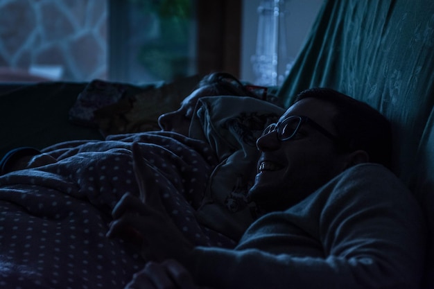 Ein lächelnder Mann mit seinem auf dem Bett liegenden Sohn