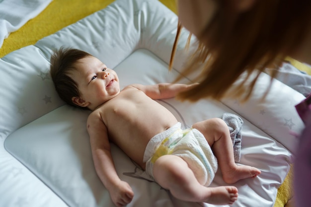 Ein lächelndes Baby liegt zu Hause im Bett