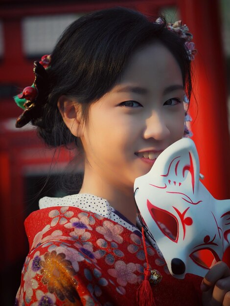 Foto ein lächelndes teenager-mädchen trägt im freien einen kimono