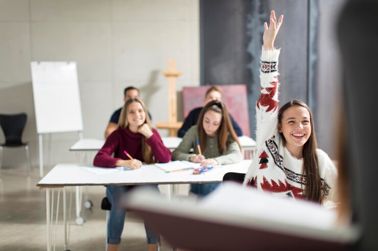 Foto ein lächelndes teenagermädchen hebt in der klasse die hand