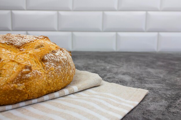 Ein Laib Brot auf einem Handtuch auf hellem Hintergrund Kopieren Sie Platz