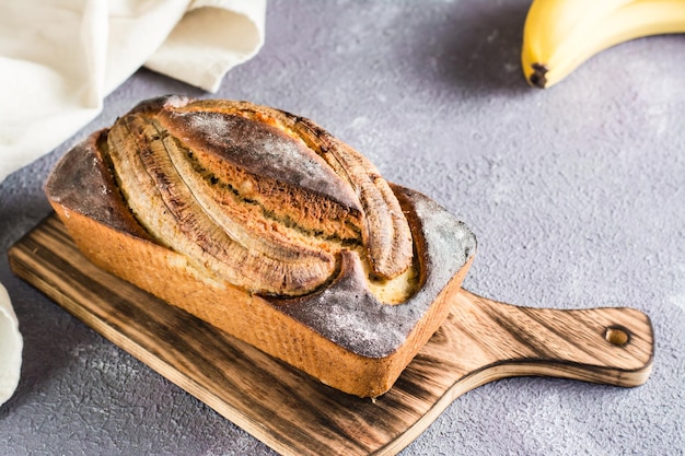 Ein Laib gebackenes Bananenbrot auf einem Schneidebrett auf dem Tisch Social Media trendy