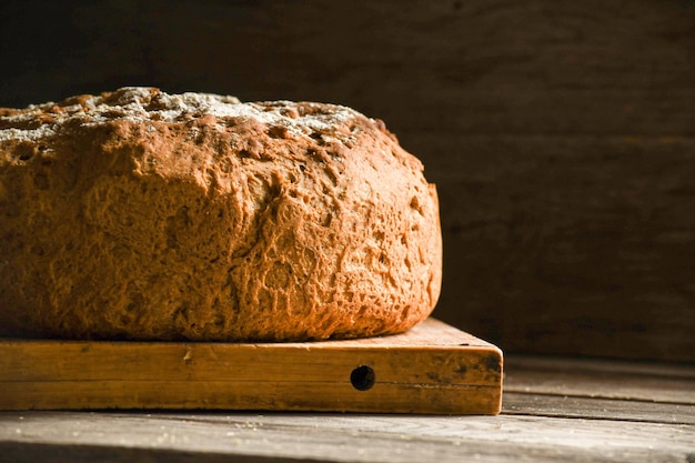 Ein Laib hausgemachtes Brot auf einem Küchenbrett auf einem Holztisch. Die Ukraine mit Brot füttern?