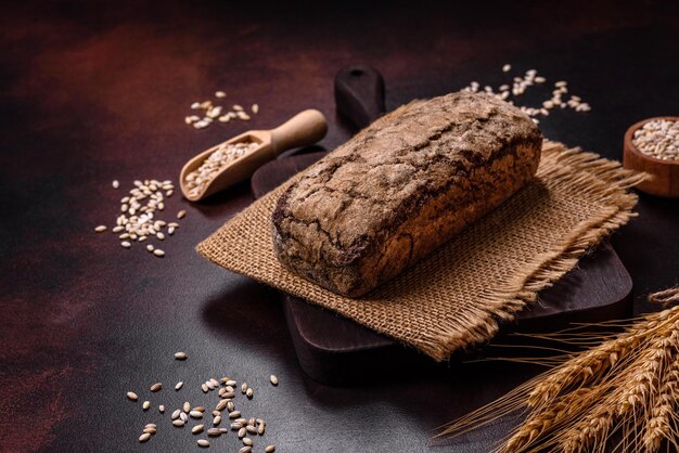 Ein Laib Schwarzbrot mit Getreidekörnern auf einem Holzschneidebrett