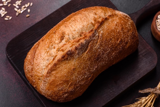 Ein Laib Schwarzbrot mit Getreidekörnern auf einem Holzschneidebrett