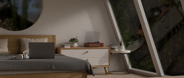 Ein Laptop auf einem Bett in einem modernen und komfortablen Schlafzimmer in einer regnerischen Nacht
