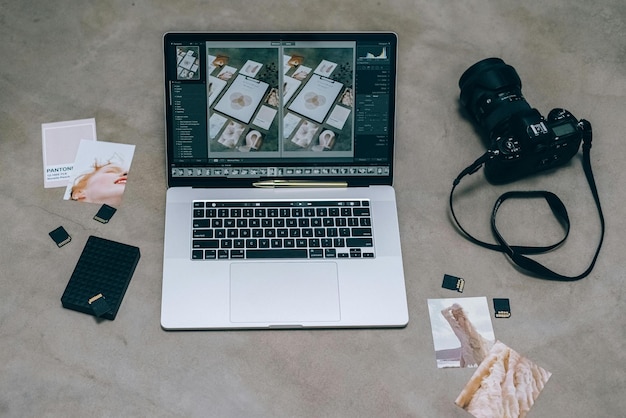 Ein Laptop in der Nähe der schwarzen DSLR-Kamera
