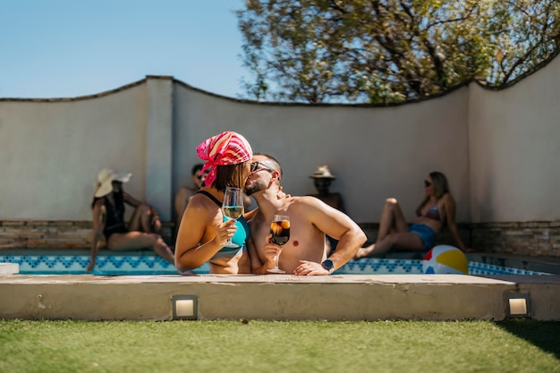 Ein lateinisches verlobtes Paar, das sich in einem Swimmingpool küsst