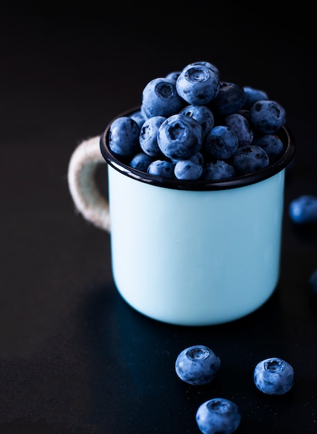 Ein leckerer und gesunder Snack: saftige und süße Heidelbeeren auf schwarzem Hintergrund