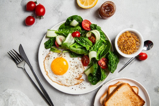 Ein leckeres und gesundes Frühstück mit gebratenen Eiern, Salat und Toast