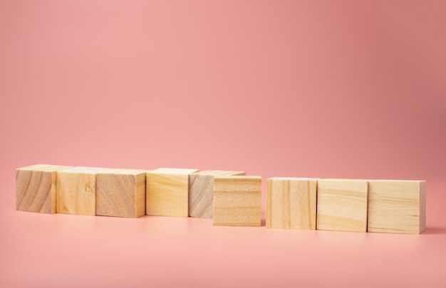 Ein leerer Holzwürfel stellte sich auf einem rosa Hintergrund auf. Damit neue Ideen ins Bild gesetzt werden.