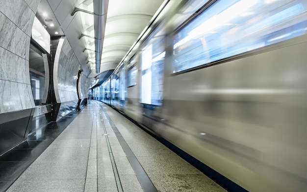 Ein leerer u-bahnsteig mit zug, der den bahnhof verlässt