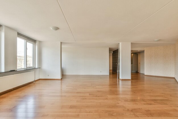 Foto ein leeres wohnzimmer mit holzflächen und großen fenstern mit blick auf die straße vor dem haus