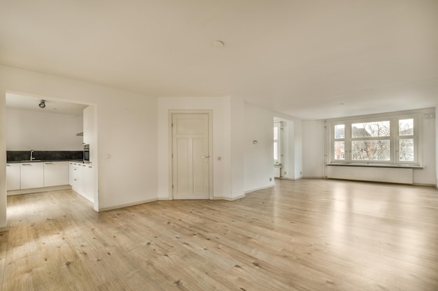 Ein leeres Wohnzimmer mit weißen Wänden und Holzböden