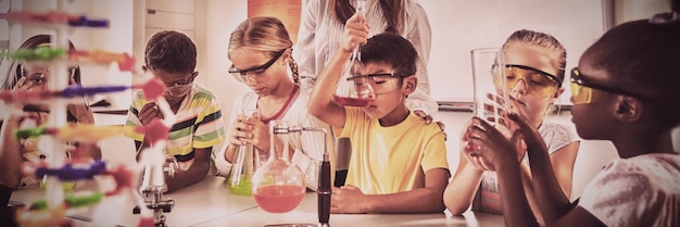 Foto ein lehrer posiert mit schülern, die ein wissenschaftsprojekt machen