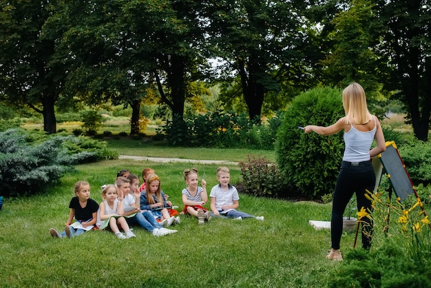 Ein Lehrer unterrichtet eine Klasse von Kindern in einem Park im Freien