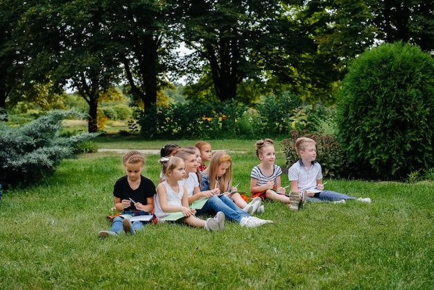 Ein Lehrer unterrichtet eine Klasse von Kindern in einem Park im Freien