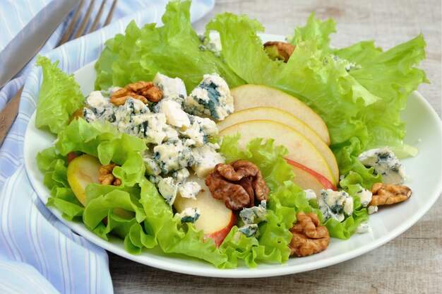 Ein leichter Salat mit Birnenscheiben, Gorgonzolastücken und Walnuss, gewürzt mit Olivenöl