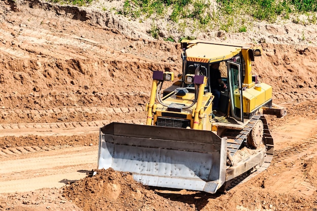 Ein leistungsstarker Bulldozer in einer Sandgrube plant einen Standort Gewinnung von Sand in einem Tagebau Naturbaustoffe