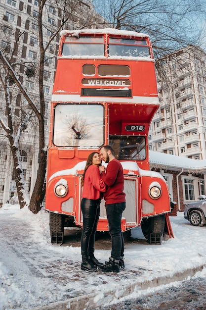 Ein liebendes Paar umarmt den Hintergrund eines roten Busses. Valentinstag. Hochwertiges Foto