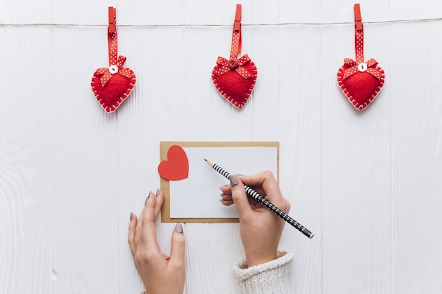 Ein Liebesbrief und dekorative Herzen auf einem weißen Hintergrund für den Valentinstag.