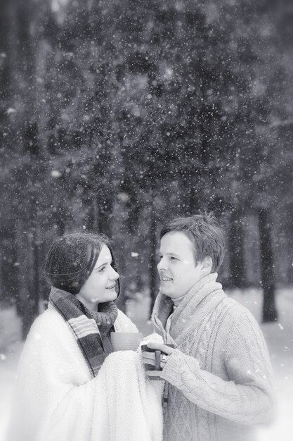 Ein Liebespaar auf einem Winterspaziergang. Mann und Frau bei einem Date im Park im Winter. Freunde in einem Winterpark