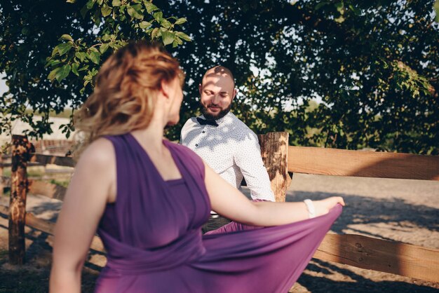 Ein Liebespaar bei einem Date im Sommergarten. Lila Kleid.