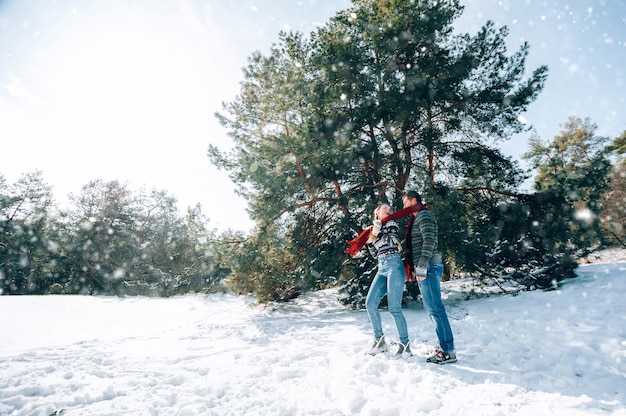 Ein liebevolles junges Paar ruht in den Bergen in einem schneebedeckten Wald. Konzept der gemeinsamen Ruhe