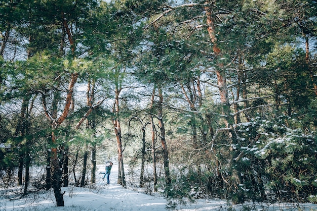 Ein liebevolles junges Paar ruht in den Bergen in einem schneebedeckten Wald. Konzept der gemeinsamen Ruhe